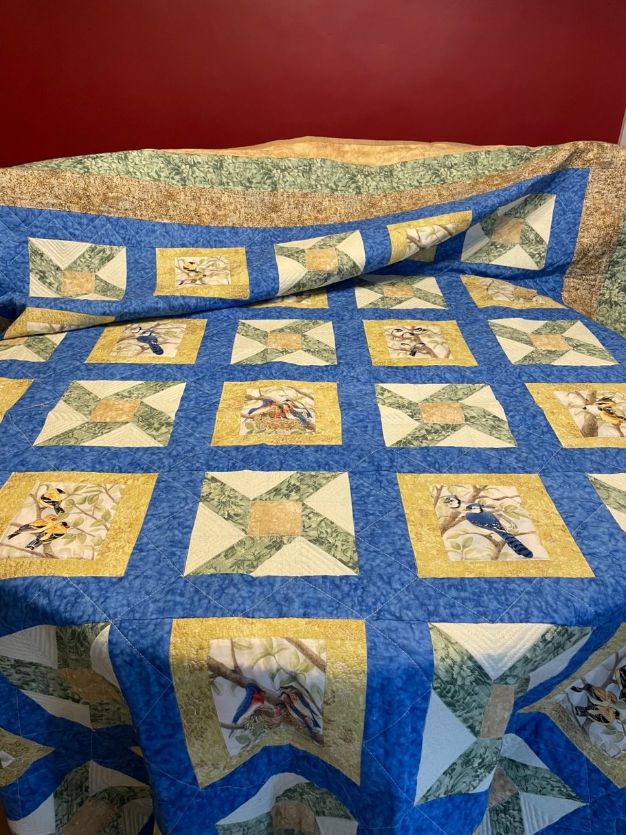 Wings and Whirl Quilt with bird panels and windmill patchwork